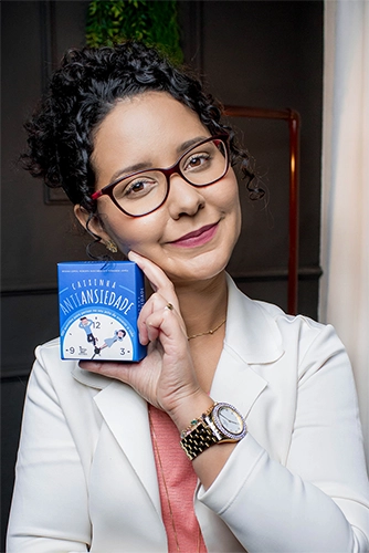 thaisa segurando uma caixa sobre ansiedade, com um sorriso no rosto